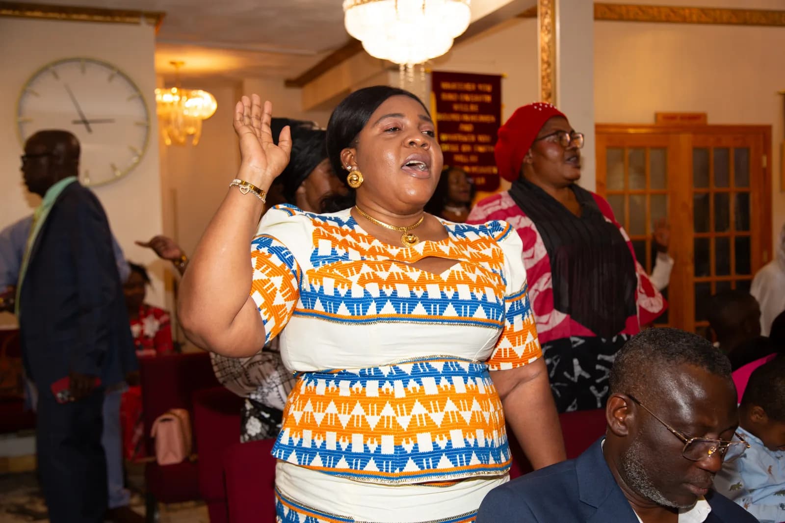 Congregation member with hand raised in heartfelt worship