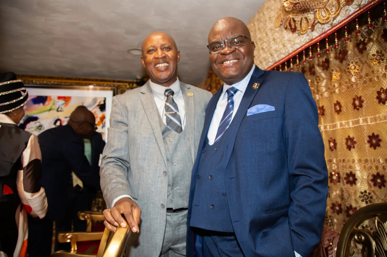 Two senior leaders in suits pose in the beautifully decorated sanctuary