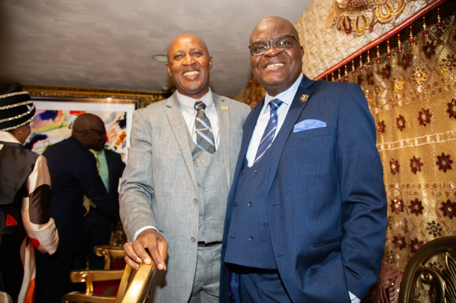 Two sharply dressed leaders share a wide, warm smile